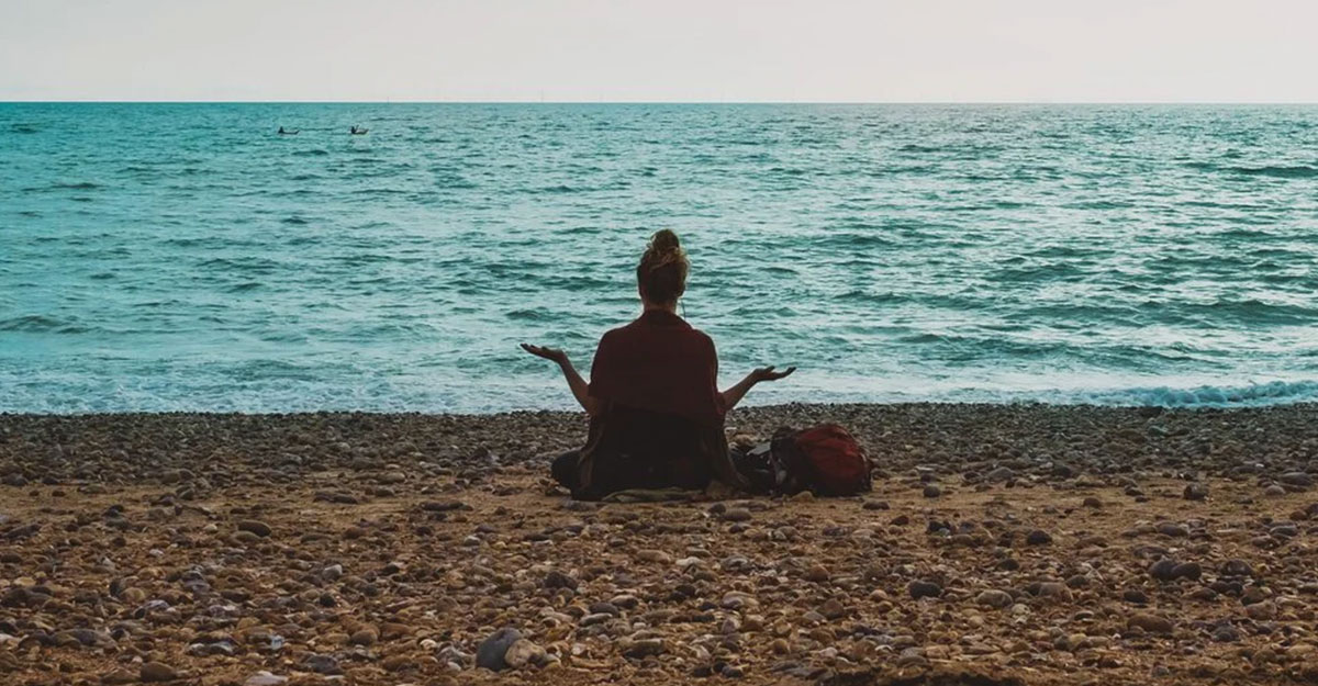a man standing on top of a sandy beach next to the ocean